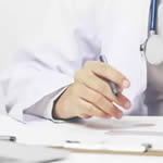 Main d’un médecin rédigeant des résultats médicaux liés à une analyse ADN ou un test de paternité