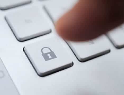 Doigt appuyant sur une touche clavier avec icône de cadenas symbolisant la sécurité et la confidentialité des données ADN