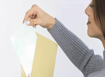 Femme insérant un document dans une enveloppe pour l’envoi d’un kit ou d’un échantillon ADN