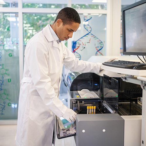 Technicien de laboratoire manipulant un analyseur automatisé pour traiter des échantillons ADN lors d’un test de paternité