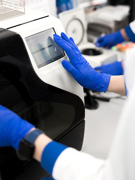 Technicien manipulant un appareil d’analyse ADN dans un laboratoire pour un test de paternité