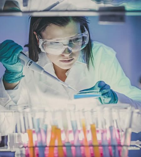 Technicienne en laboratoire examinant des échantillons fluorescents dans le cadre d’un test ADN