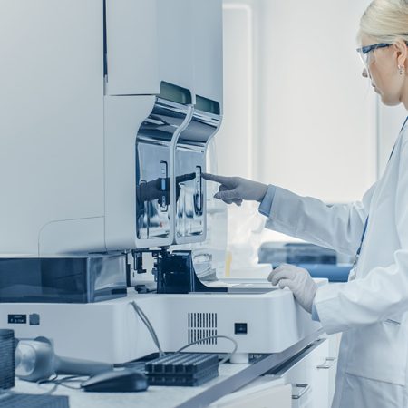 Technicienne de laboratoire utilisant un séquenceur ADN pour des analyses génétiques